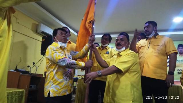 Sekretaris Partai Golkar Sumbar, Desra Ediwan AT menyerahkan panji Partai Golkar pada Yakub Saguruk usai terpilih secara aklamasi pada Musda V yang digelar di Padang, Sabtu (20/3/2021).